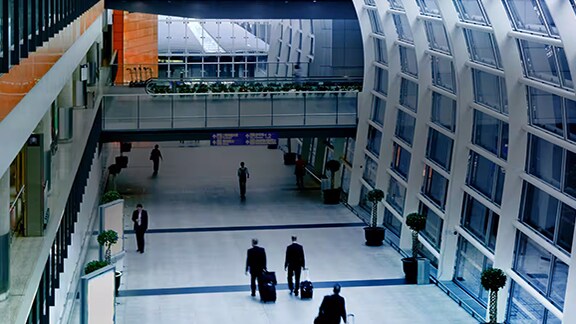 Motion-blur image of people walking in an airport lobby