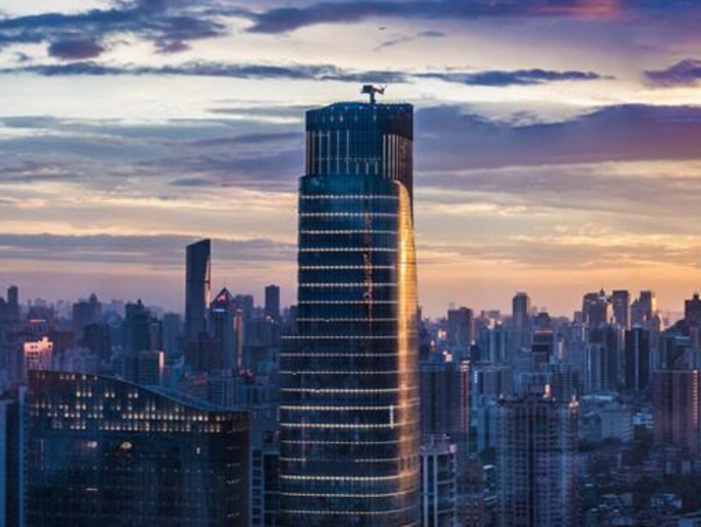 The image depicts a tall building, with a significant tower visible in the background